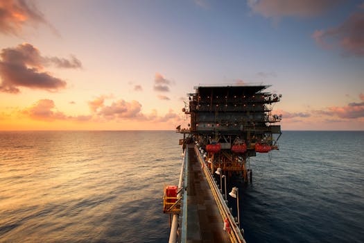 A breathtaking view of an oil platform on the ocean at sunset, showcasing industrial beauty.